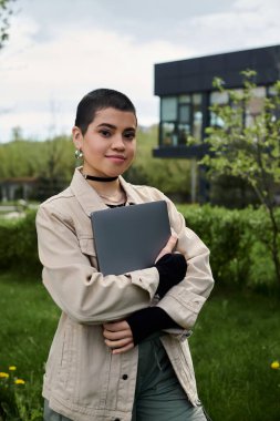 A young woman stands in a field, connecting with technology while surrounded by nature. clipart