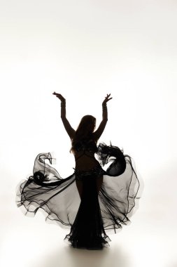 Young woman in black dress performing a graceful dance. clipart
