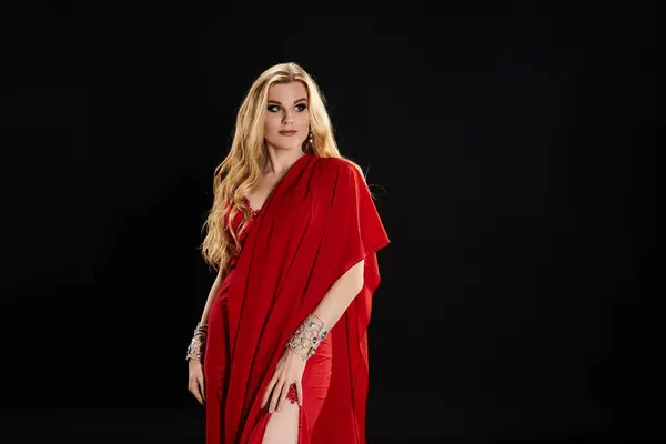 stock image Graceful woman in a white dress and red cape performing a mesmerizing dance.