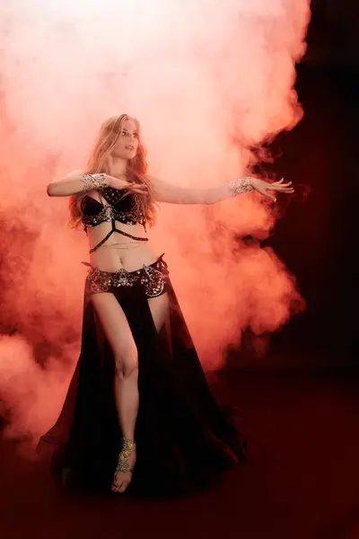 stock image Young woman in vibrant belly dance attire striking a pose for the camera.