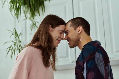 lgbt çifti yan yana dururlar, günlük kıyafetleriyle sevgi ve kabullenme yayarlar..