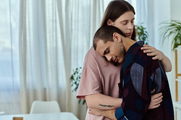 A gay couple in casual clothes sharing a heartfelt embrace at home.