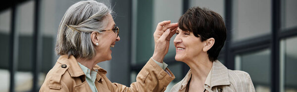 Две женщины, стоящие рядом, касаясь лба рукой в момент близости.