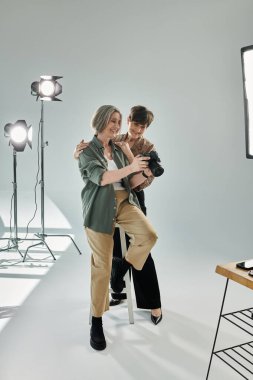 Stüdyoda orta yaşlı bir lezbiyen çift, kameradaki fotoğrafları kontrol ediyor.