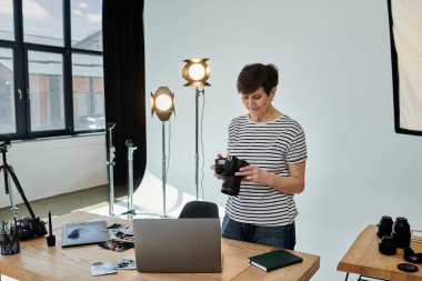 Bir kadın, yaratıcı amaçlar için dijital içeriği yakalayan bir kamerayı ustalıkla dizüstü bilgisayarın önünde tutuyor..