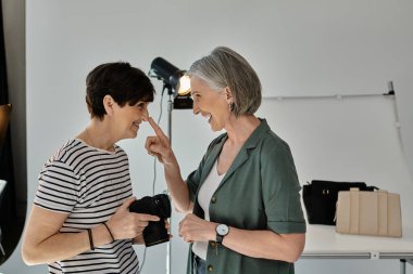 Orta yaşlı lezbiyen çift modern fotoğraf stüdyosunda sevimli anlar yaşıyor..