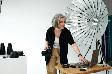 Bir kadın dizüstü bilgisayarın önünde duruyor, ileri teknoloji bir çalışma alanındaki bir projede işbirliği yapıyor..