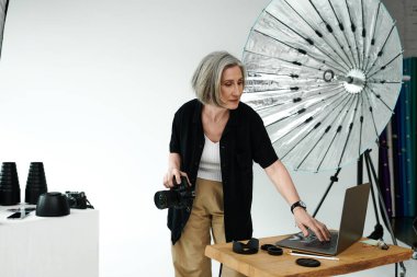 A woman stands engaged in front of a laptop, collaborating on a project in a tech-forward workspace. clipart