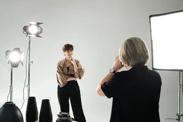 stock image Middle aged lesbian couple in photo studio, woman capturing partner in front of camera.