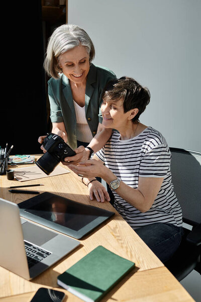 Женщины, занимающиеся творческой работой вместе за столом в современной студии.