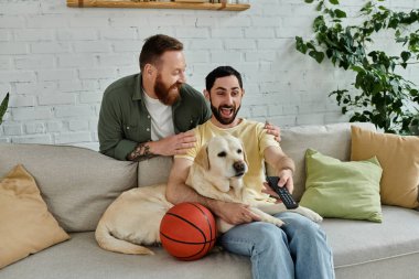 Sakallı bir adam bir Labrador 'un yanındaki koltukta dinlenir. İkisi de rahat bir oturma odasında güzel vakit geçirir..