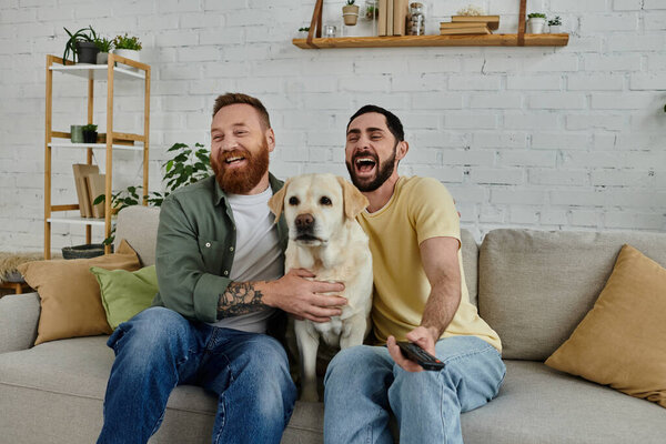 Бородатая гей-пара сидит на диване, обнимая своего счастливого лабрадора в теплой и уютной гостиной.