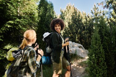 İki genç kadın, lezbiyen bir çift, yemyeşil bir ormanda yürüyüş yapıyorlar..