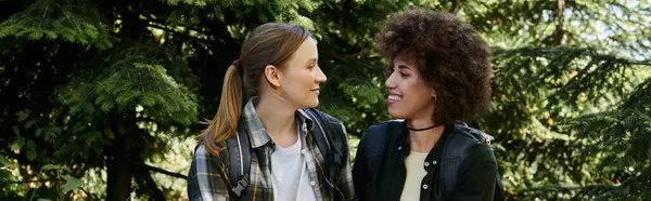 stock image A lesbian couple on a hike, enjoying a scenic walk through a lush forest.