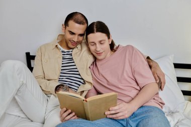 İki genç adam, eşcinsel bir çift, modern dairelerinde bir yatakta rahatlar ve birlikte kitap okurlar..