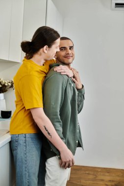 A young gay couple shares a tender moment in their modern apartment. clipart