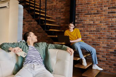 Genç eşcinsel bir çift, modern çatı katında rahatlar ve birbirlerine eşlik ederler..