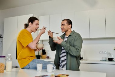 Genç eşcinsel bir çift modern dairelerinde gündelik bir kahvaltı yapıyor..