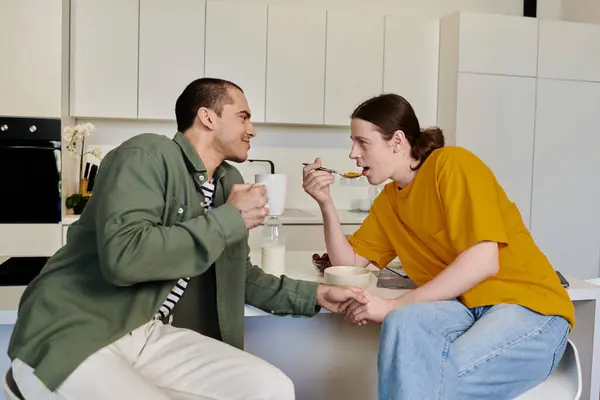 stock image A young gay couple enjoys breakfast together in their modern apartment.