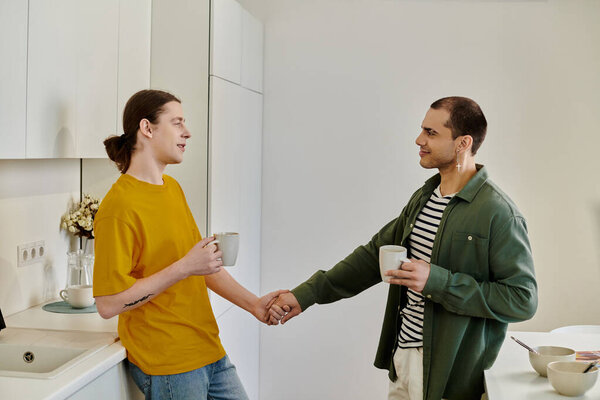 A young gay couple enjoys a morning coffee together in their modern apartment.
