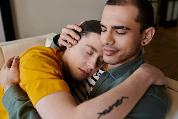 A young gay couple cuddles on a couch in their apartment, showcasing intimacy and comfort.
