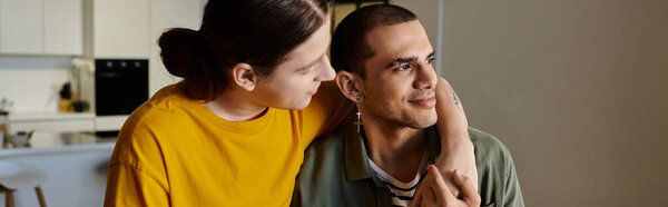 Молодая гей-пара, одетая в обычную одежду, делится нежным моментом в своей современной квартире.