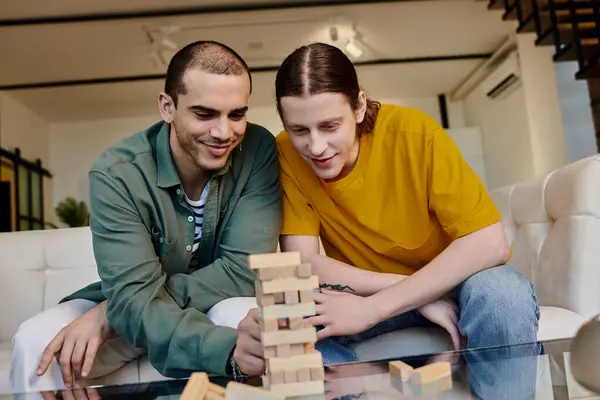 stock image A young gay couple plays a game of blocks in their modern apartment.