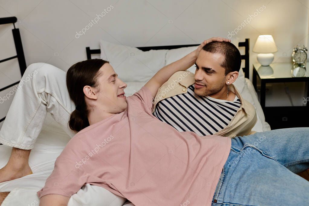 A young gay couple relaxes and enjoys each others company in a modern apartment.