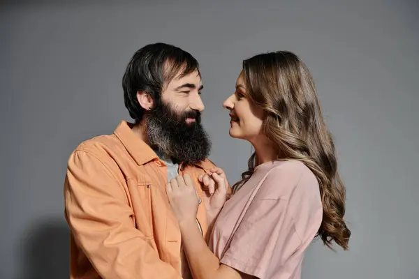 stock image A loving couple poses in front of a gray backdrop, showcasing their affection for each other.