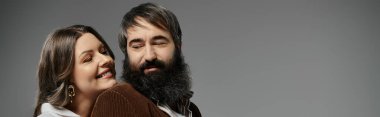 Zarif giyimli bir çift birbirlerine sevgiyle bakar..