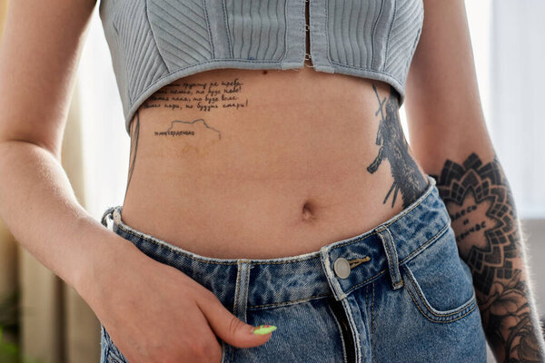 A young woman with multiple tattoos relaxes at home in a modern apartment, enjoying a cozy weekend.