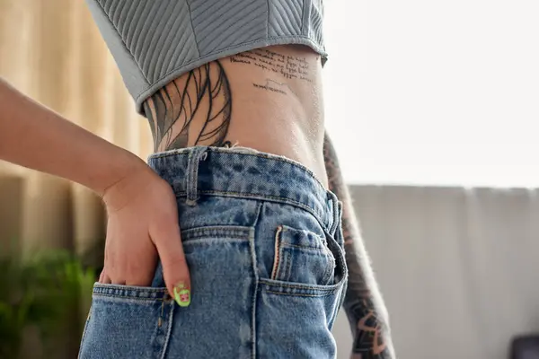 stock image A young woman with tattoos relaxes in her modern apartment, enjoying a cozy weekend at home.