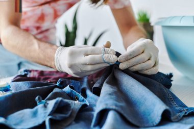 Genç bir tasarımcı atölyesine kot kumaşı dikiyor. Eski kıyafetlere yeni bir hayat vererek sürdürülebilirliğe odaklanıyor..