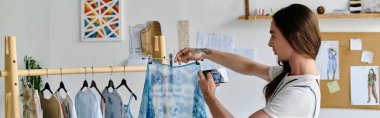 A young gay man meticulously examines a piece of clothing in his DIY clothing restoration atelier, showcasing his passion for sustainability and giving old items a new life. clipart