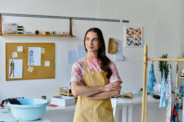 Молодой человек стоит в ателье по реставрации одежды, готовый работать над тем, чтобы дать старой одежде новую жизнь.