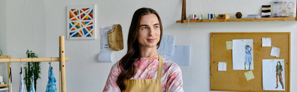 A young man, wearing an apron, stands in his clothing restoration atelier, focused on giving new life to discarded clothing.