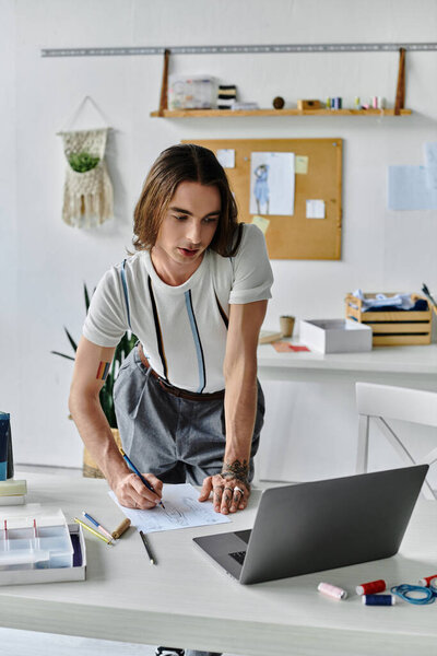 A young man meticulously sketches designs in his clothing restoration atelier, where he gives new life to discarded garments.