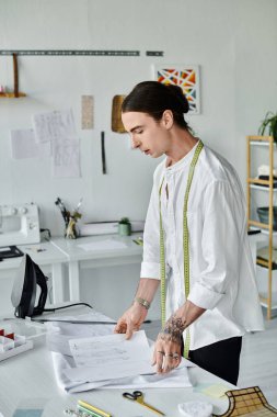 Genç bir terzi, parlak, minimalist atölyesinde bir kıyafet modelini titizlikle inceliyor. Çökmüş kıyafetlere yeni bir hayat vermek, sürdürülebilir moda uygulamalarını desteklemek için çalışıyor..