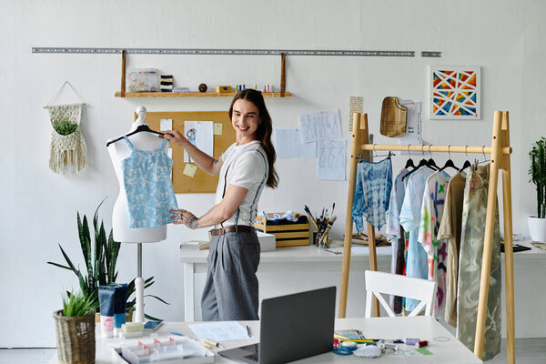 Молодой человек в мастерской по реставрации одежды демонстрирует свою страсть к устойчивой моде, преобразуя выброшенную одежду.