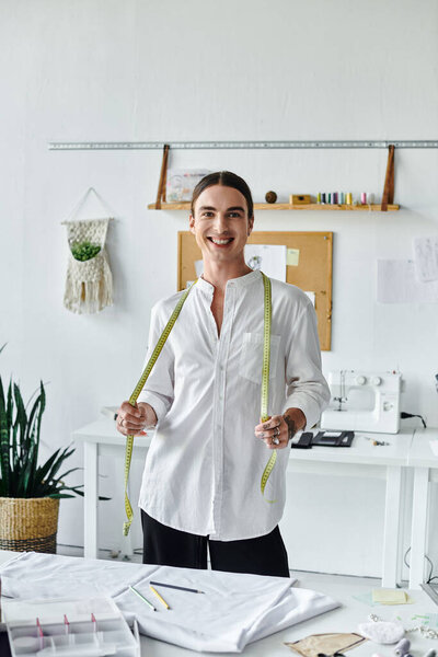 A young tailor in a white shirt stands in his clothing restoration atelier, holding a measuring tape, ready to transform discarded clothes into new masterpieces.