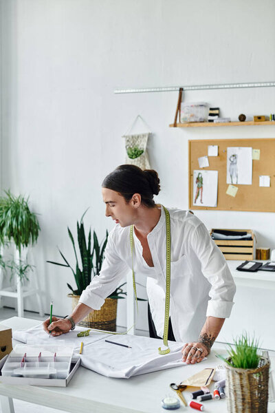 A young tailor, dressed in a white shirt, works on a clothing project in his DIY atelier.
