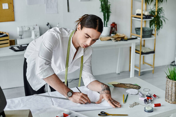 Молодой человек тщательно измеряет ткань в своей мастерской по реставрации одежды. Он фокусируется на устойчивости, давая выброшенной одежде новую жизнь..