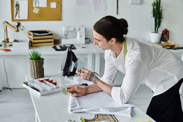 Молодой человек тщательно изучает кусок ткани в мастерской по реставрации одежды..