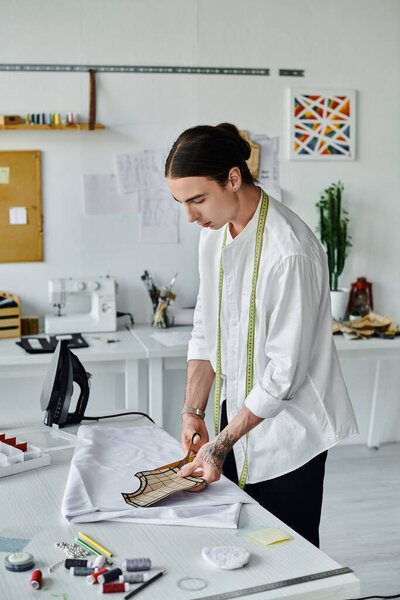 Молодой человек в белой рубашке работает над проектом реставрации одежды в своем ателье, сосредоточенный на устойчивости и возрождении выброшенной одежды..