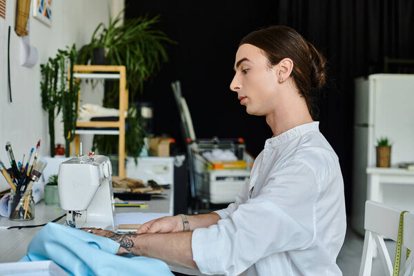 A young man, dressed in white, meticulously sews discarded fabrics, transforming them into unique garments in his DIY clothing restoration atelier.