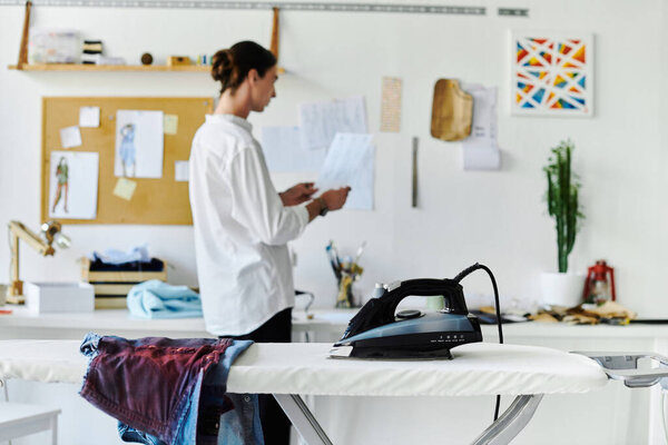 A young man, focused on sustainability, restores and transforms old clothing in his DIY clothing atelier.
