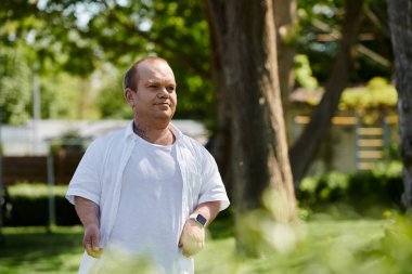 A man with inclusivity walks through a lush green park. clipart