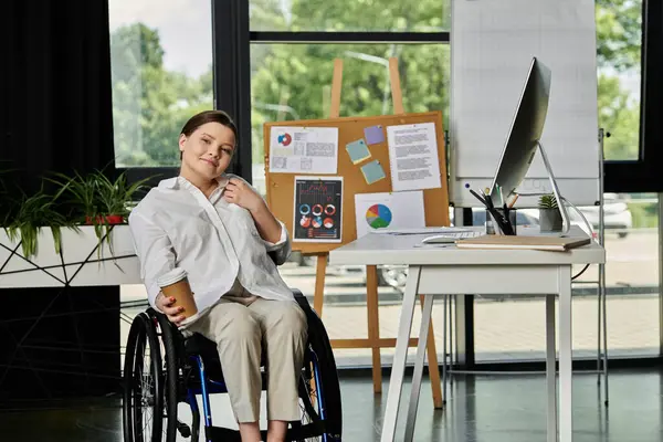 stock image A young businesswoman in a wheelchair is working in a modern office.