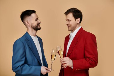 Two men in suits raise glasses of champagne, smiling at each other. clipart