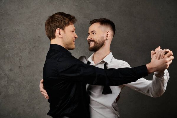A gay couple in elegant suits embrace and dance together.